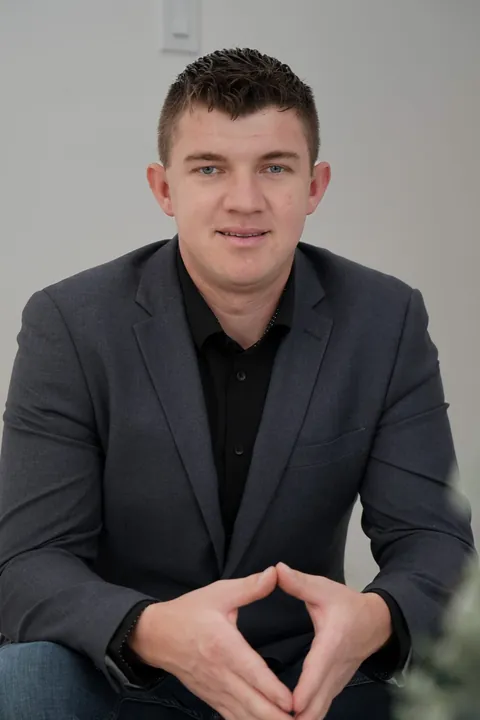 Abe Thiessen, seated, hands together, facing the camera